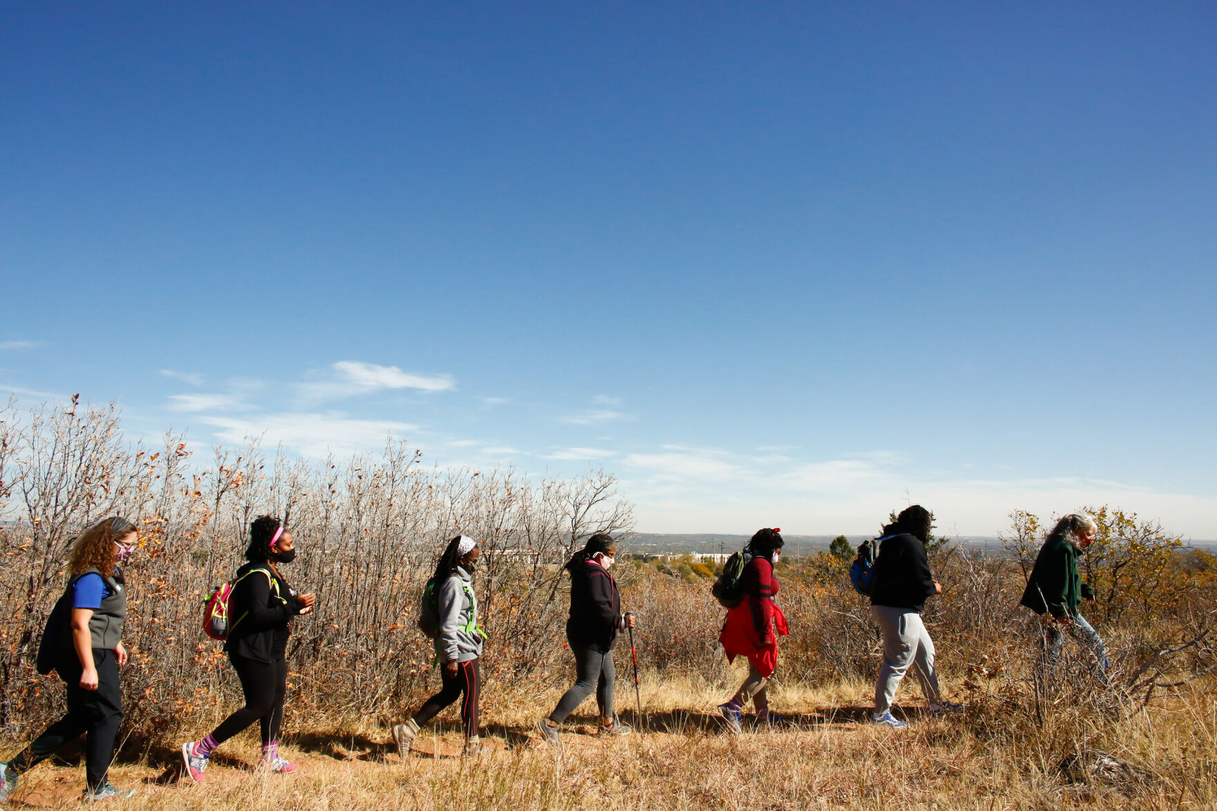 From left, Theresa Odello, Jessica Newton, Jan Garduno, Ashanta Cyprian, Joy Eloi and Jewyl Newton follow park volunteer Lynn Wilson during a hike through Bear Creek Regional Park in Colorado Springs, Colorado, on Oct. 24, 2020.
